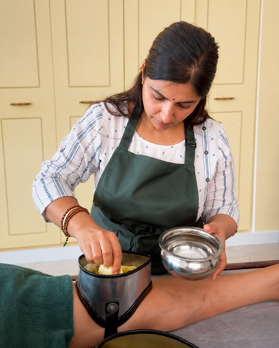Woman receiving Shirodhara in a traditional Ayurvedic treatment setting